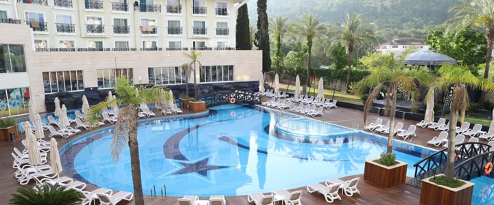 Blick auf die beeindruckende Poolanlage des Hotels Meder Resort, eingepasst in die Kulisse des Hotels, Im Hintergrund die grüne Natur.